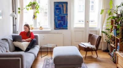 Young businesswoman sitting on couch and working on laptop computer. Female working at home using laptop.