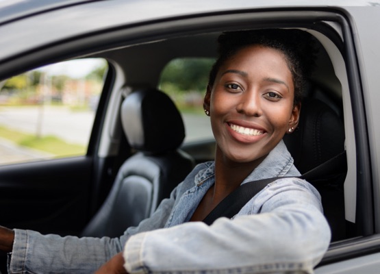 Portrait of young afro woman driving a car