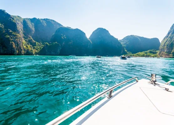 Baot heading to Maya bay in a sunshine day the beach with lush green