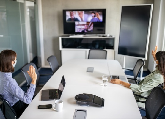 Business people having a video call in office. Business team doing a meeting over internet during pandemic.