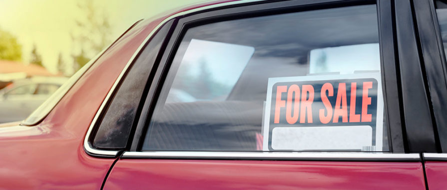 red car with for sale sign in rear passenger window