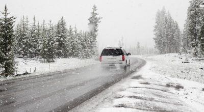 White SUV driving on a road in the winter