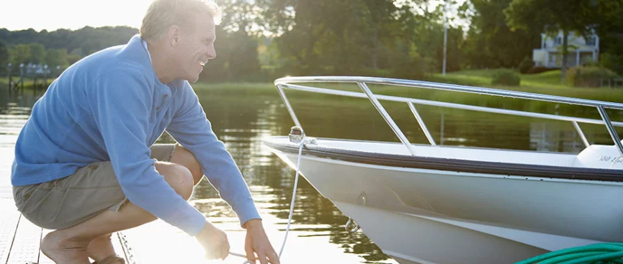 middle aged man tying up a boat at a dock.